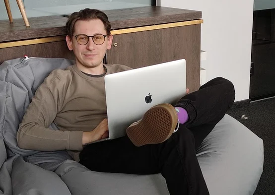 Jaroslav at a conference standing against a blue background.